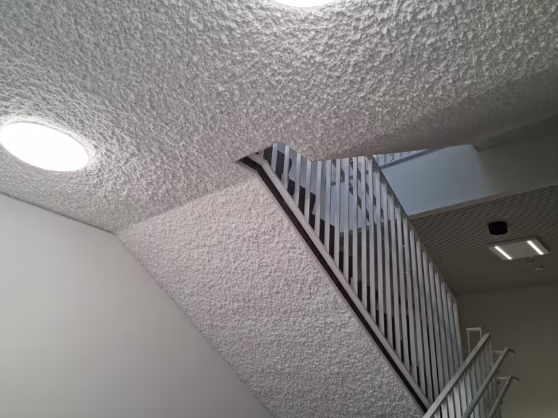 Seamless acoustic ceiling application in a hallway